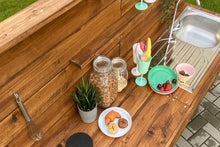 Lade das Bild in den Galerie-Viewer, Kinder Matschküche aus Holz bei Regenwetter im Garten