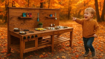 Kinder Matschküche aus Holz mit lachendem Kind im Herbst im Kindergarten 