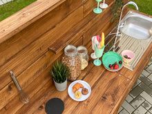 Lade das Bild in den Galerie-Viewer, Kinder Matschküche aus Holz bei Regenwetter im Garten
